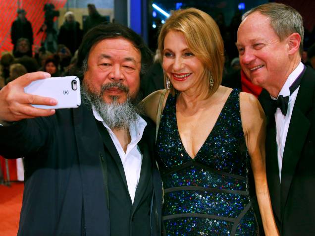 Artista chinês Ai Weiwei, posa para selfie com o embaixador americano na Alemanha, John Emerson, e sua esposa Kimberly, ao chegar no tapete vermelho, para a exibição do filme Ave, César, durante a abertura de gala do Festival de cinema de Berlim, nesta quinta (11)