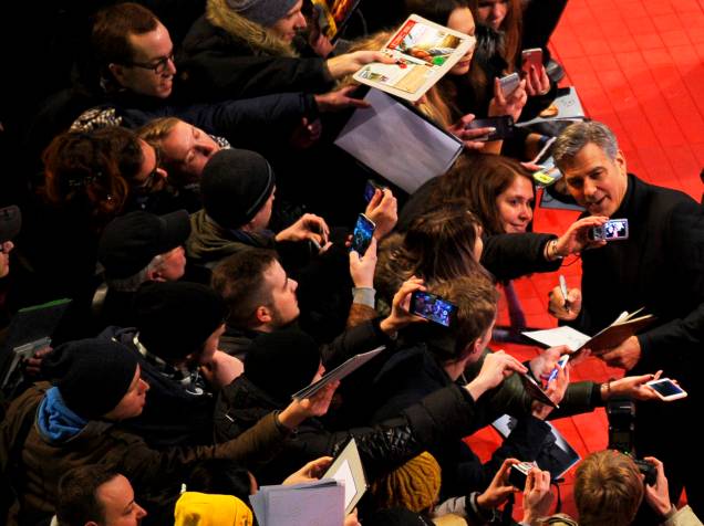 Ator americano George Clooney, posa para foto com uma fã, na chegada ao tapete vermelho. O filme Ave, César, protagonizado por ele, será exibido na abertura do Festival de cinema de Berlim, na Alemanha, nesta quinta (11)