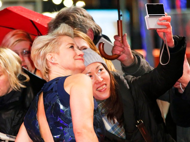 Atriz Trine Dyrhol faz selfie com uma fã, ao chegar ao tapete vermelho, para a exibição do filme The Commune, no Festival Internacional de Cinema, em Berlim, na Alemanha, nesta quarta-feira (17)