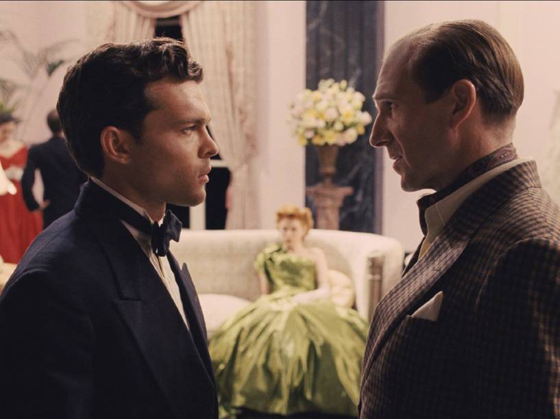 Hobie Doyle (Alden Ehrenreich), astro de faroeste, é treinado pelo diretor Laurence Laurentz (Ralph Fiennes) em Ave, César!
