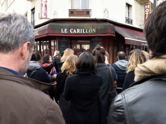 Pessoas fazem minuto de silêncio em frente ao restaurante Carillon, local de um dos ataques terroristas simultâneos em Paris