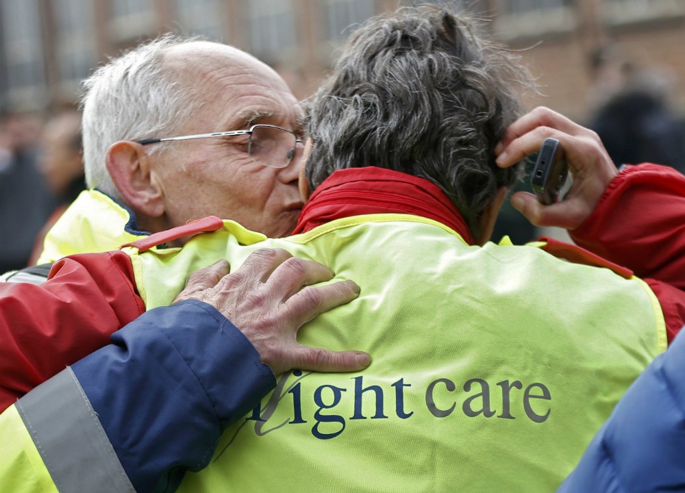 Funcionários do Aeroporto de Bruxelas se abraçam após o ataque terrorista