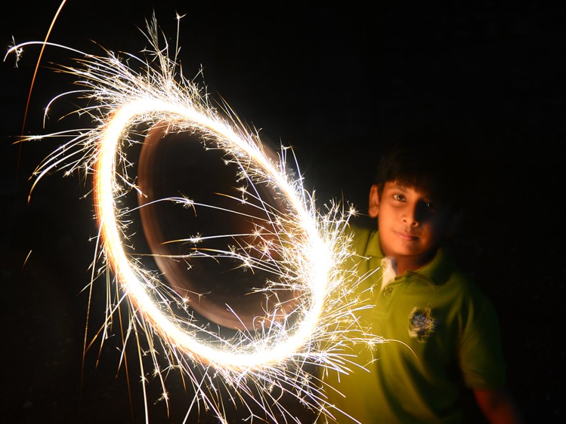 Um menino do Sri Lanka comemora o ano novo com pequenas luzes 
