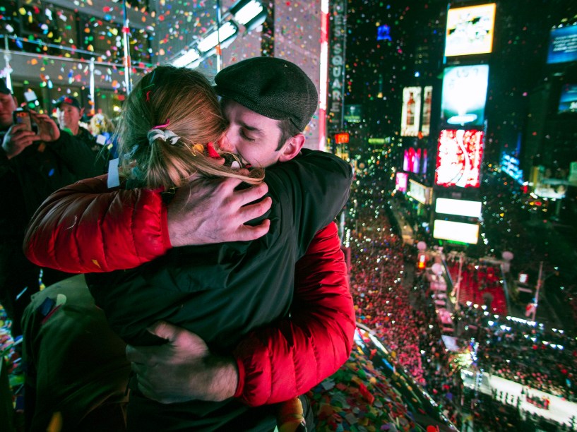 Casal de abraça em varanda de hotel na Times Square durante a virada do ano em Nova York