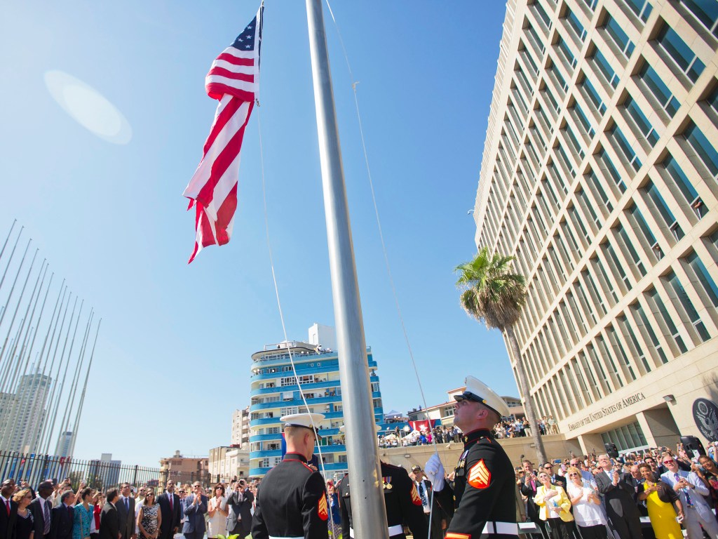 Soldados erguem bandeira dos Estados Unidos durante cerimônia de reabertura da embaixada do país em Havana