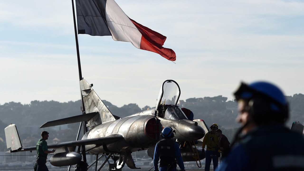 Soldados preparam um avião-caça Rafale no porta-aviões Charles de Gaulle, em Toulon, sul da França