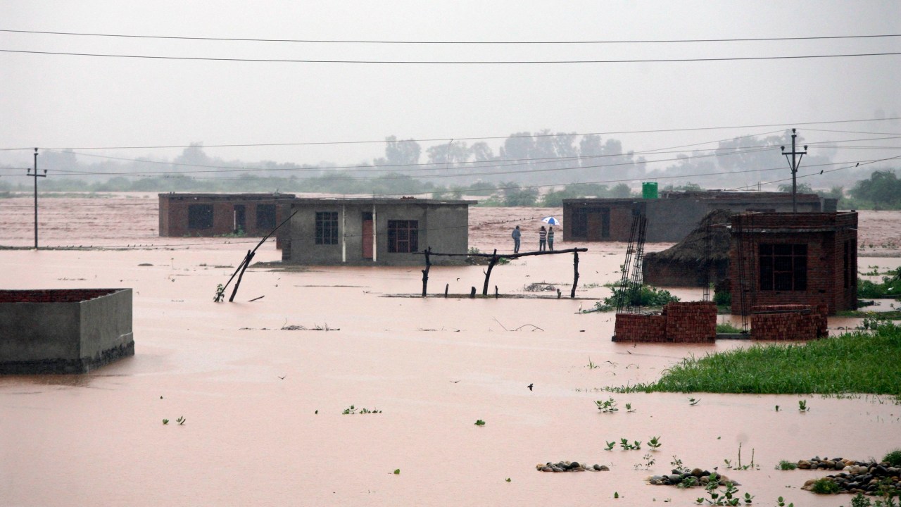 Dezenas de casas ficaram submersas nas margens alagadas do rio Tawi após as fortes chuvas na Índia