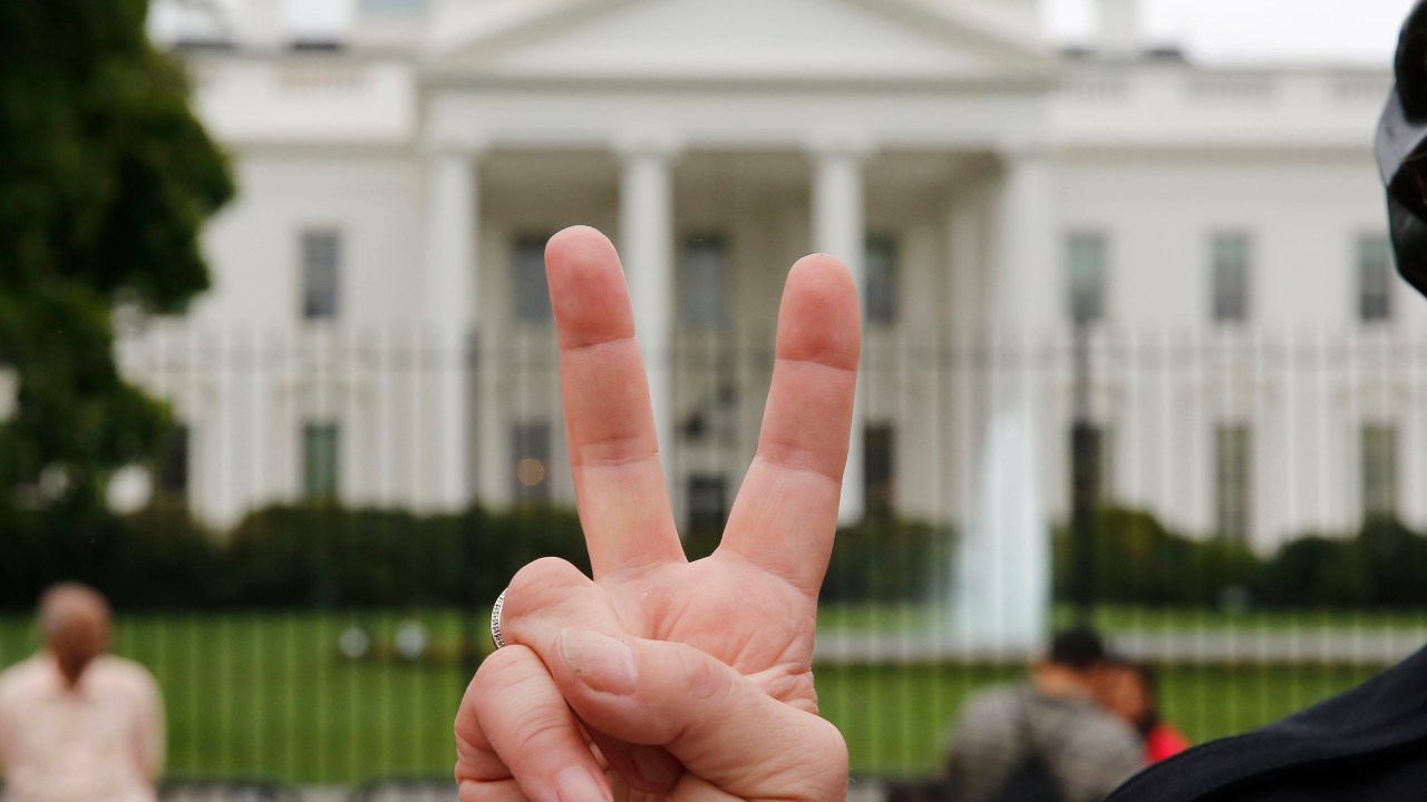 Um manifestante do grupo ativista 'ANSWER' faz sinal de paz durante uma manifestação contra o bombardeio americano na Síria, em frente a Casa Branca, em Washington