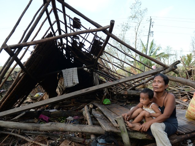Nas Filipinas, sobreviventes ao lado de sua casa destruída pelo tufão Hagupit. Pelo menos 21 pessoas morreram e mais de um milhão foram para abrigos para se proteger da tempestade