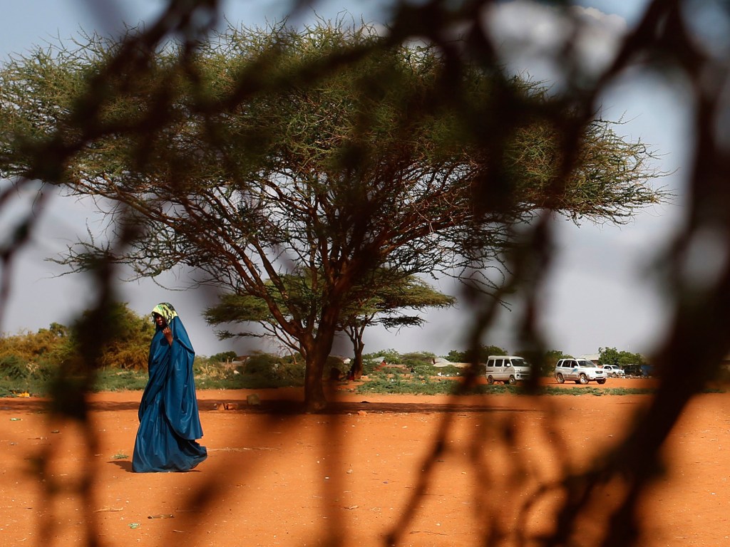Mulher atravessa a linha de fronteira entre a Somália e o Quênia, na cidade de Mandera