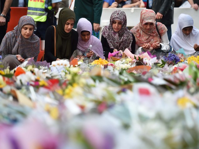 Jovens depositam flores em memorial em frente ao local onde um homem armado fez reféns e deixou mortos na véspera no centro do distrito financeiro de Sydney, na Austrália