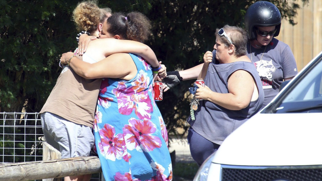 Mulheres choram em frente à casa onde foram encontradas oito crianças mortas a facadas na cidade de Cairns, no Estado de Queensland, na Austrália