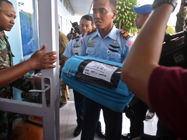 Membro da força aérea indonésia carrega um item recuperado do mar de Java durante as operações de busca e salvamento da aeronave da AirAsia, em Pangkalan Bun, na Indonésia - 30/12/2014