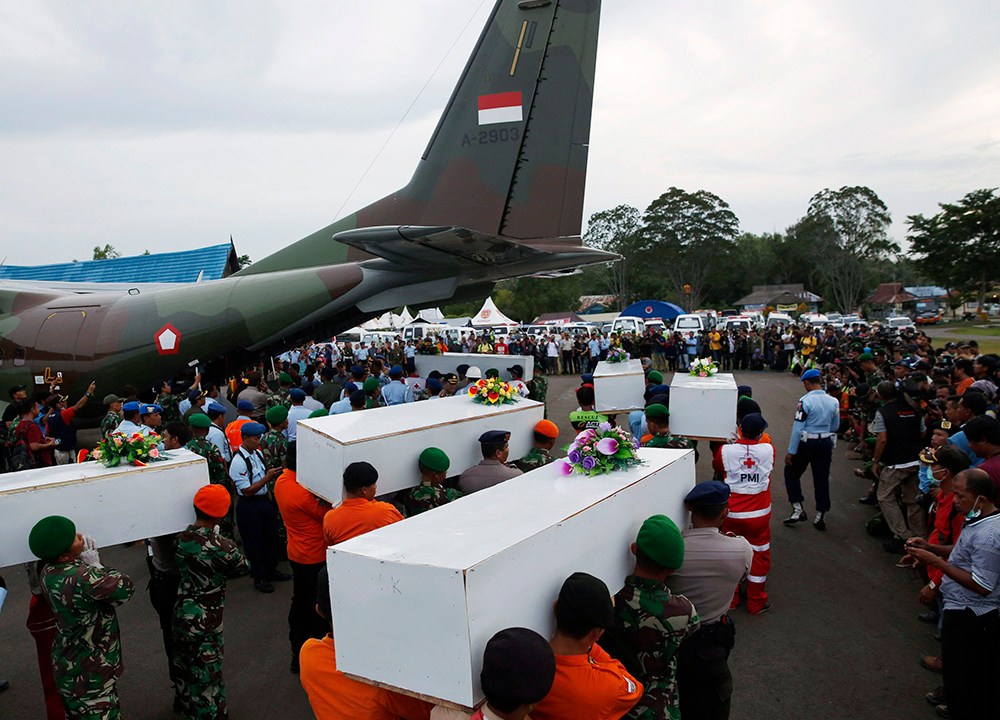 Caixões contendo os restos mortais dos passageiros do AirAsia QZ8501 recuperados do mar são transportados para um avião militar antes de serem levados a Surabaya, onde o voo teve origem, no aeroporto de Pangkalan Bun, Indonésia