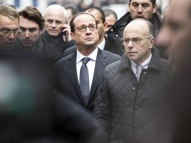 O presidente francês, Francois Hollande (ao centro), chega ao escritório da revista satírica Charlie Hebdo em Paris após tiroteio que matou ao menos 12 pessoas