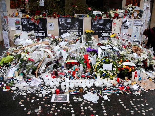 Velas, canetas, cadernos, lápis e flores são postos em frente à sede do jornal francês satírico Charlie Hebdo, em homenagem às vítimas dos ataques ao local