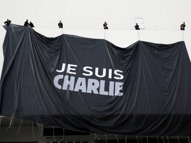 Operários estendem uma grande lona com a frase Je suis Charlie em homenagem às vítimas dos ataques ao jornal Charlie Hebdo na entrada do Palácio dos Festivais de Cannes, na França - 09/01/2015