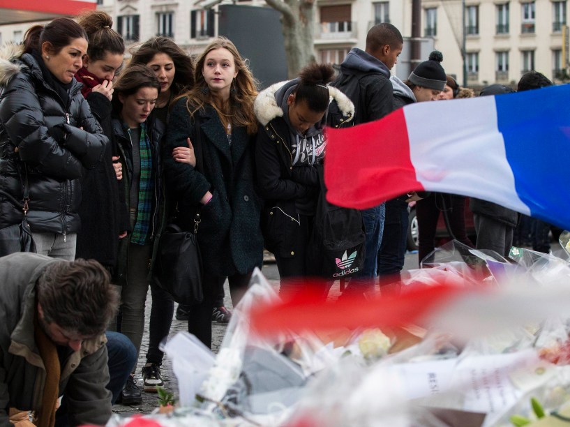 Pessoas deixam flores, velas e mensagens em frente ao mercado kosher onde quatro reféns foram mortos, em Paris , na França