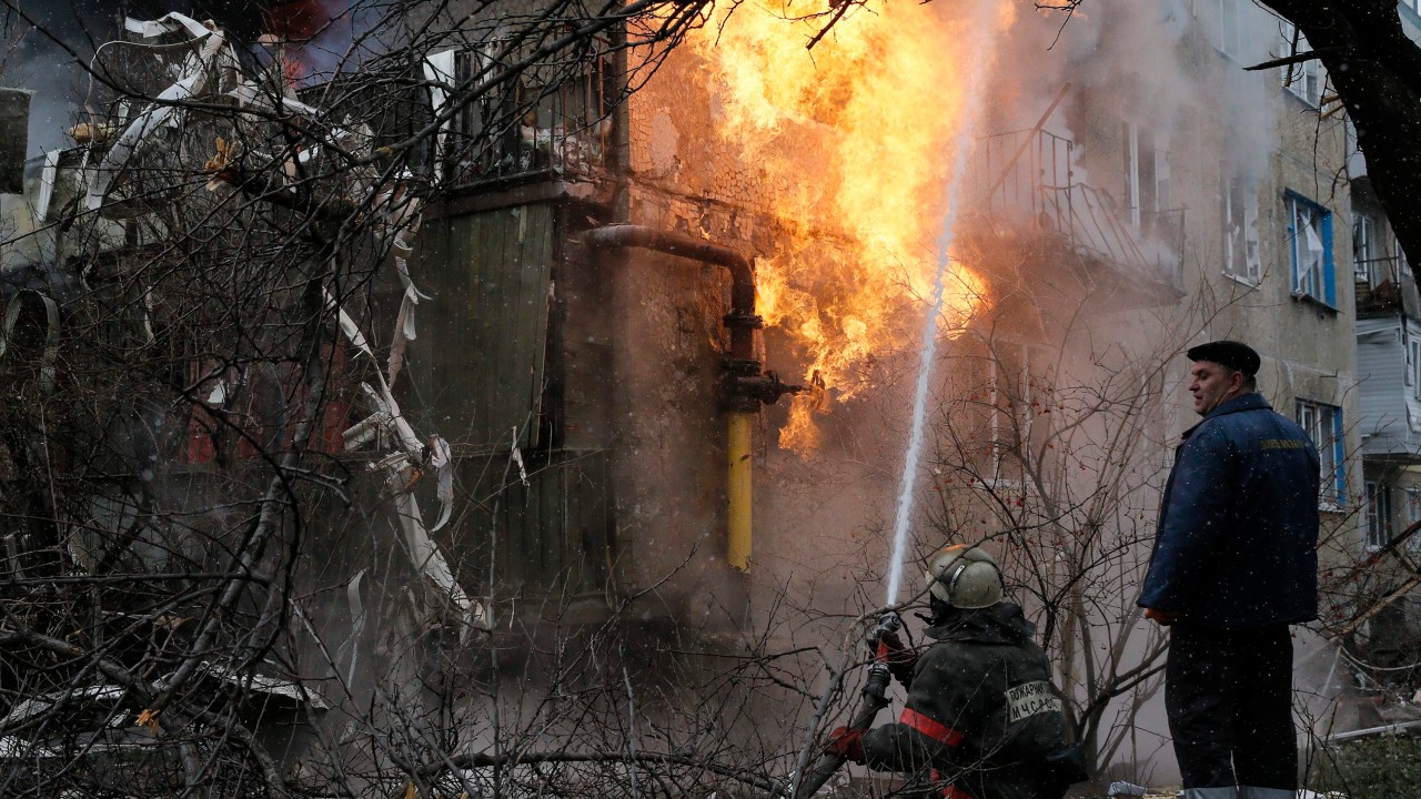 Bombeiro tenta combater incêndio em uma casa que foi bombardeada em Donetsk, leste da Ucrânia