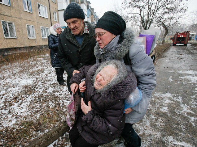 Idosa é acolhida após o prédio em que ela morava ser atingido por um bombardeio nos arredores de Donetsk, leste da Ucrânia