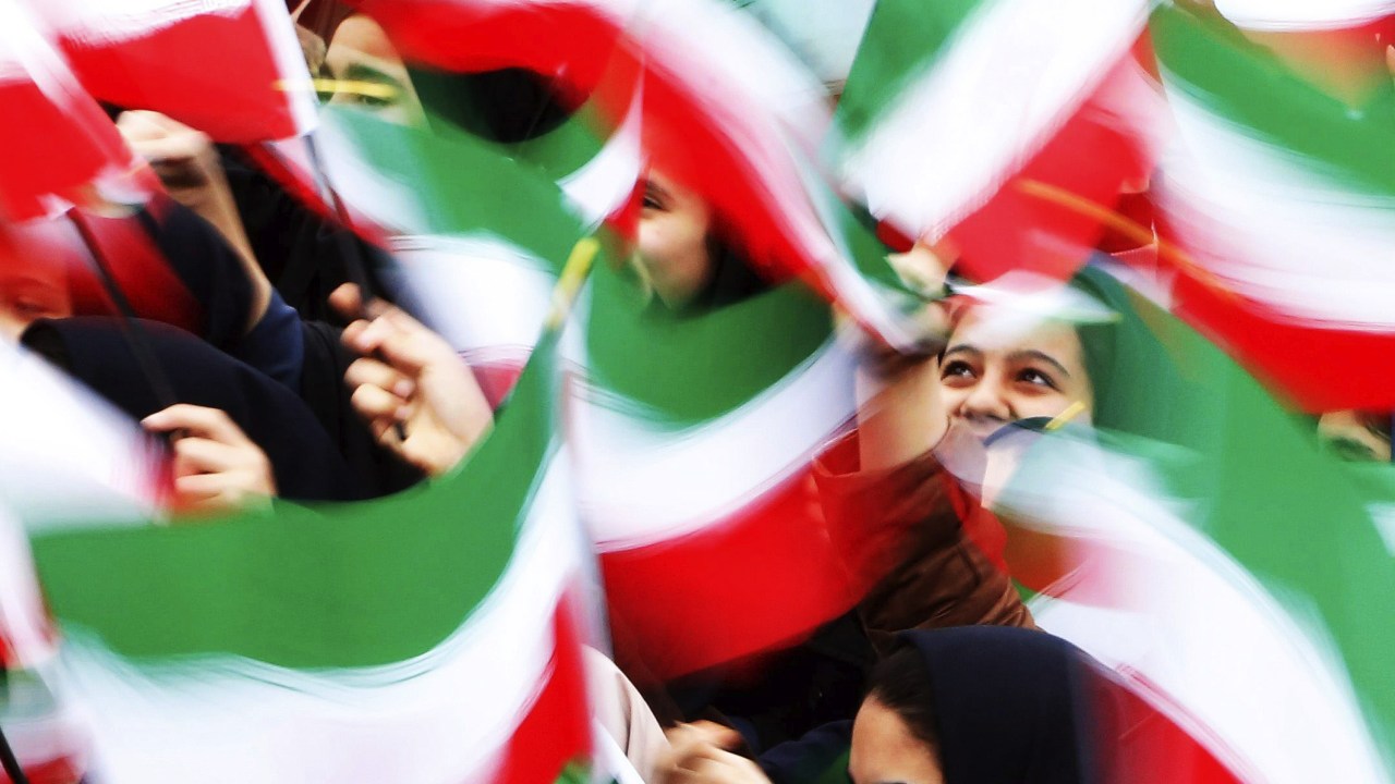 Estudantes agitam bandeiras iranianas durante uma cerimônia em comemoração ao 36º aniversário da vitória da Revolução Islâmica, em 1979, que derrubou o último xá do Irã, Mohammed Reza Pahlevi, em Teerã - 11/02/2015