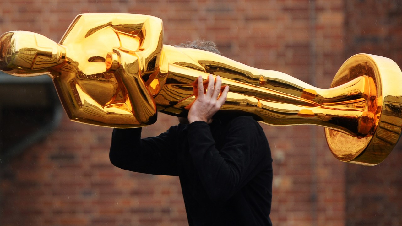 Homem carrega uma estátua de Oscar para um evento de imprensa realizado pela Filmstudios Babelsberg, local onde foram gravadas cenas do filme Grande Hotel Budapeste, em Potsdam, na Alemanha - 23/02/2015