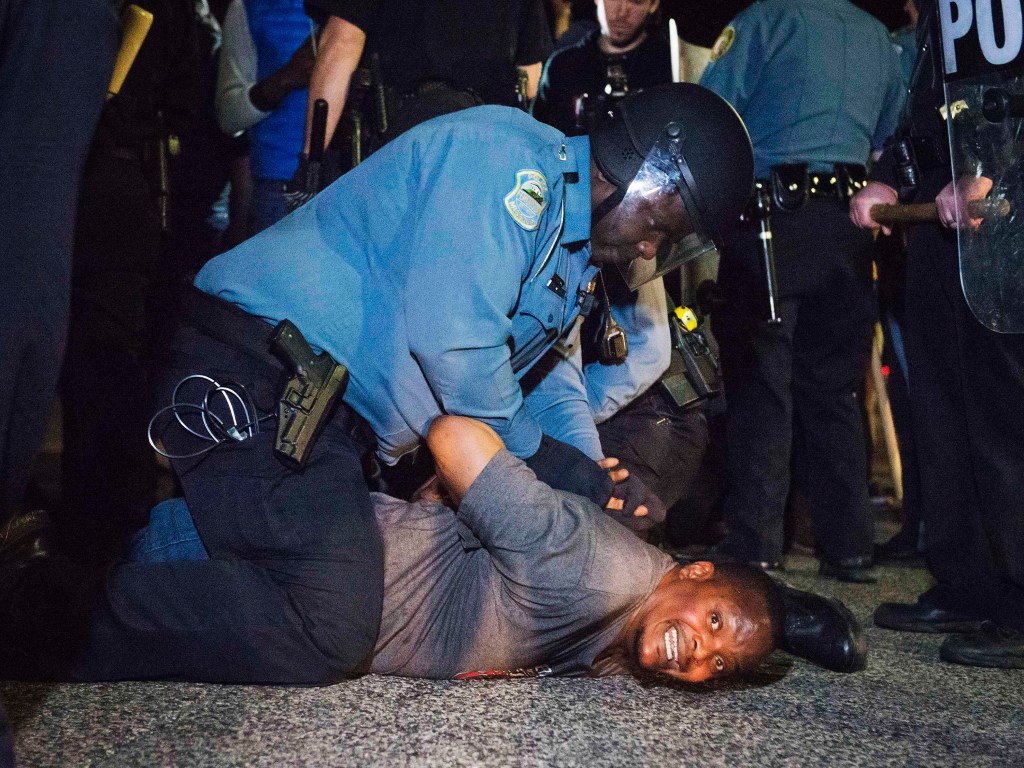 Policial prende um manifestante do lado de fora do Departamento de Polícia de Ferguson, no estado do Missouri (EUA). O protesto começou após ao chefe da polícia, Tom Jackson, renunciar o cargo - 12/03/2015