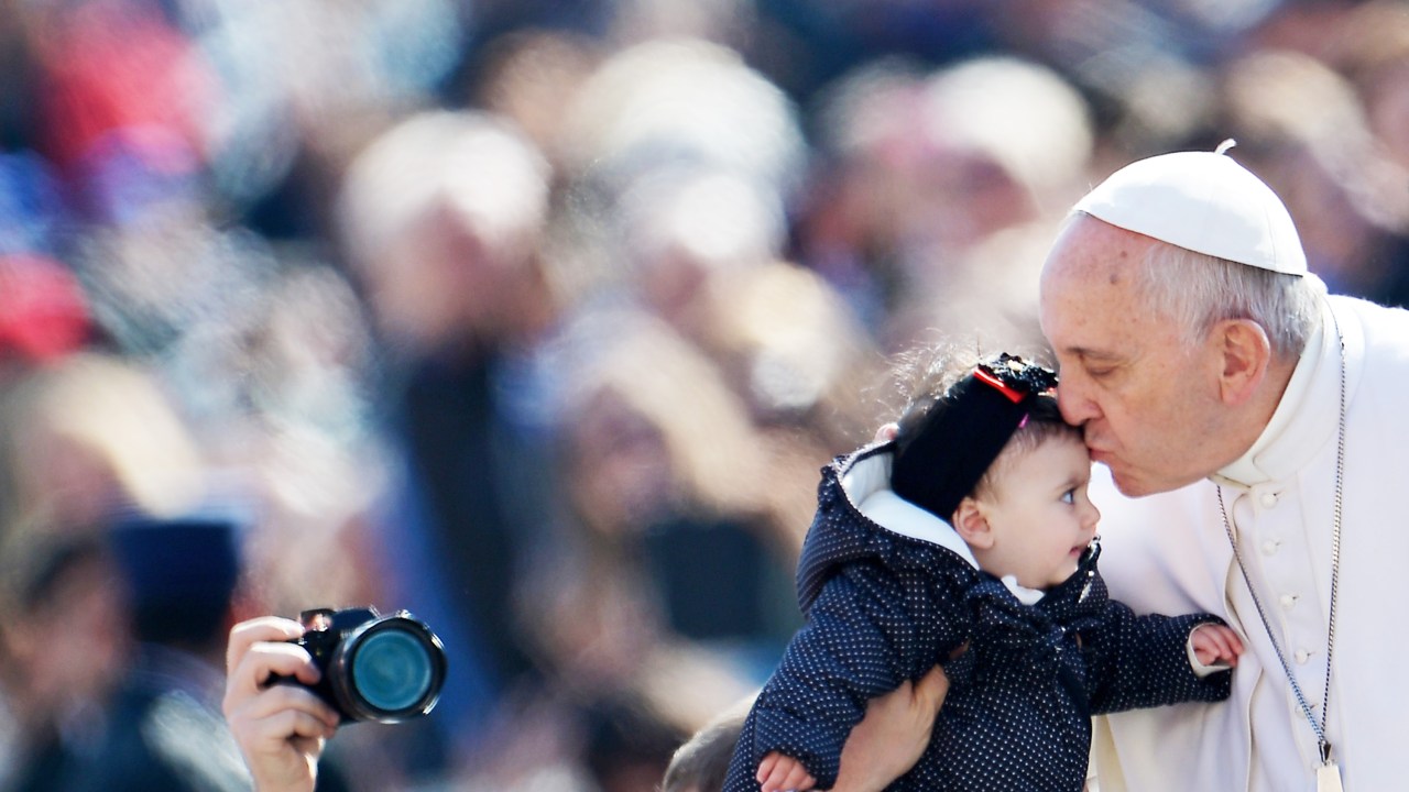 Papa Francisco beija uma bebê em sua chegada ao Vaticano para a audiência geral semanal - 18/03/2015