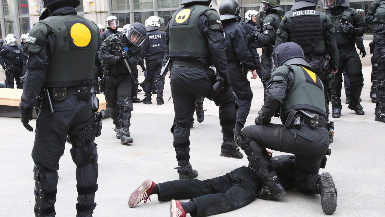 Policiais detém manifestante durante marcha contra a reunião dos ministros das Relações Exteriores do G7 em Lubeck, na Alemanha - 14/04/2015