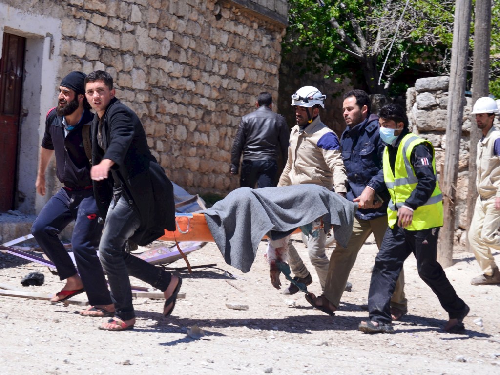 Membros da Defesa Civil socorrem vítima após ataques aéreos contra o presidente Bashar al-Assad, em Idlib, Síria - 24/04/2015