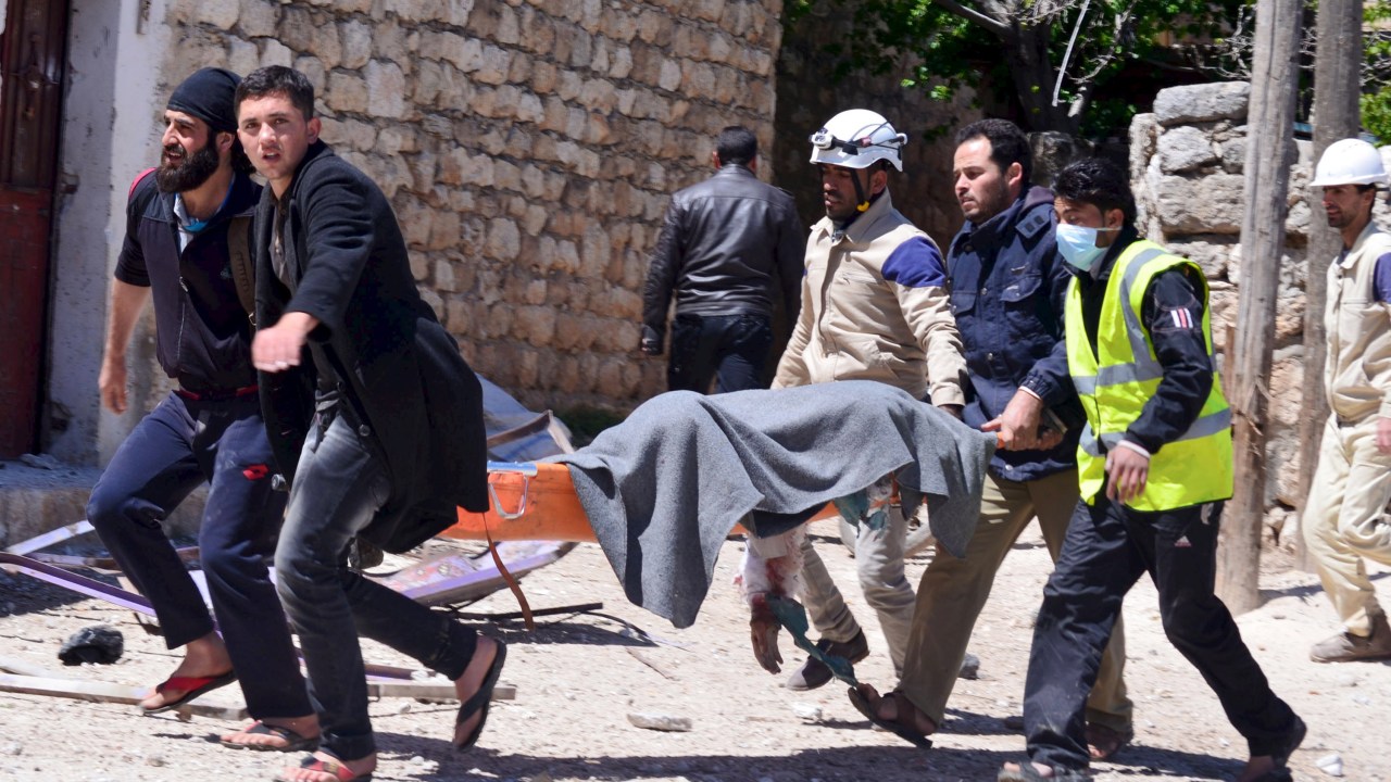 Membros da Defesa Civil socorrem vítima após ataques aéreos contra o presidente Bashar al-Assad, em Idlib, Síria - 24/04/2015