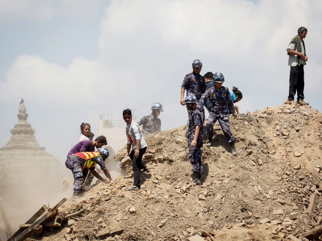 Em Kathmandu, Nepal, policiais e voluntários procuram por sobreviventes em meio aos escombros de um templo destruído pelo terremoto que devastou a região - 27/04/2015