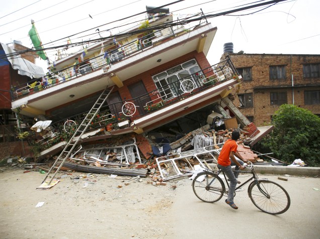 Garoto observa os destroços de uma casa que desabou após terremoto em Kathmandu, Nepal - 28/04/2015