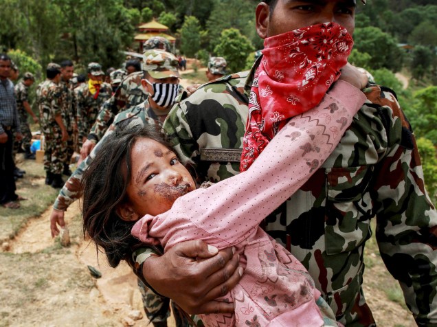 Menina ferida no terremoto do último sábado, é carregada por soldado até um helicóptero em Sindhupalchowk, Nepal - 28/04/2015