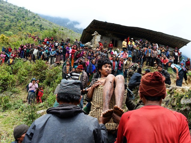 Homem ferido no terremoto do último sábado, é carregado por nepaleses até um helicóptero na vila de Uiya, no Nepal