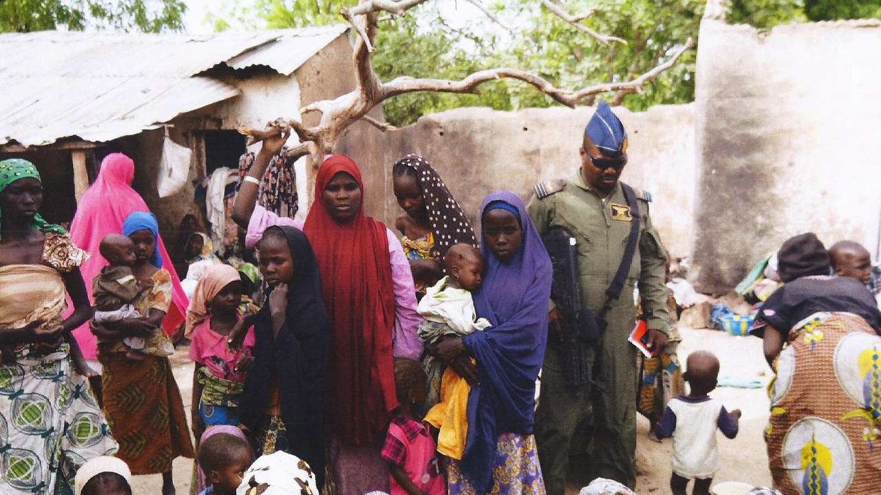 Soldado do Exército nigeriano fala com as mulheres e crianças reféns que foram libertados das mãos do grupo terrorista Boko Haram, em Yola