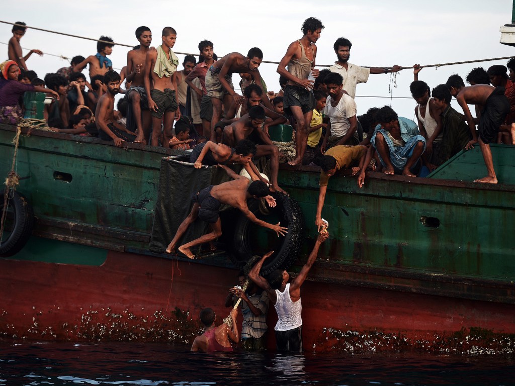 Migrantes da etnia muçulmana Rohingya presos em um barco à deriva tentam recolher os alimentos lançados por um helicóptero do exército tailandês ao largo da ilha do sul de Koh Lipe no mar de Andaman, na Tailândia - 14/05/2015