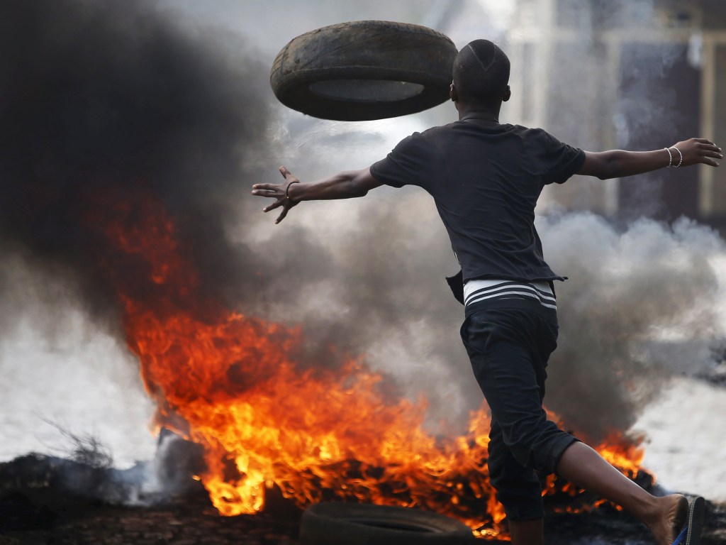 Em Bujumbura, Burundi, manifestante arremessa pneu durante protesto contra o presidente Pierre Nkurunziza - 26/05/2015