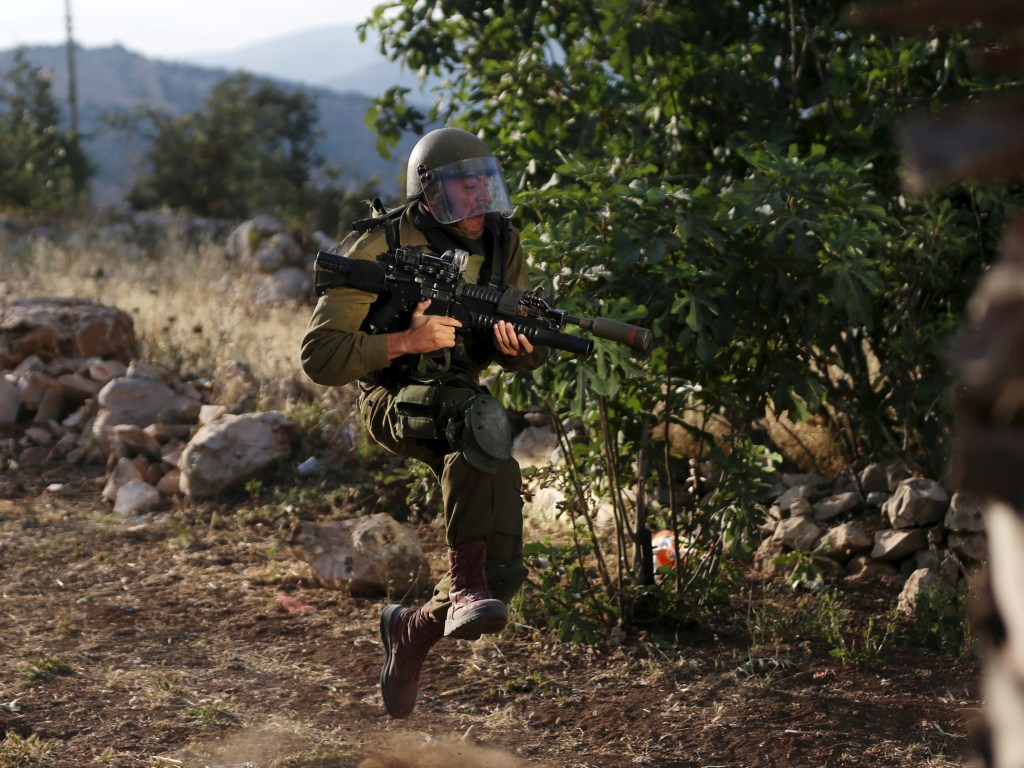Soldado israelense corre durante confronto com manifestantes palestinos na vila de Silwad - 05/06/2015