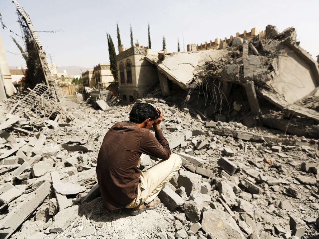 Guarda senta sobre escombros de casas destruídas após ataques aéreos em Sanaa, no Iêmen - 15/06/2015
