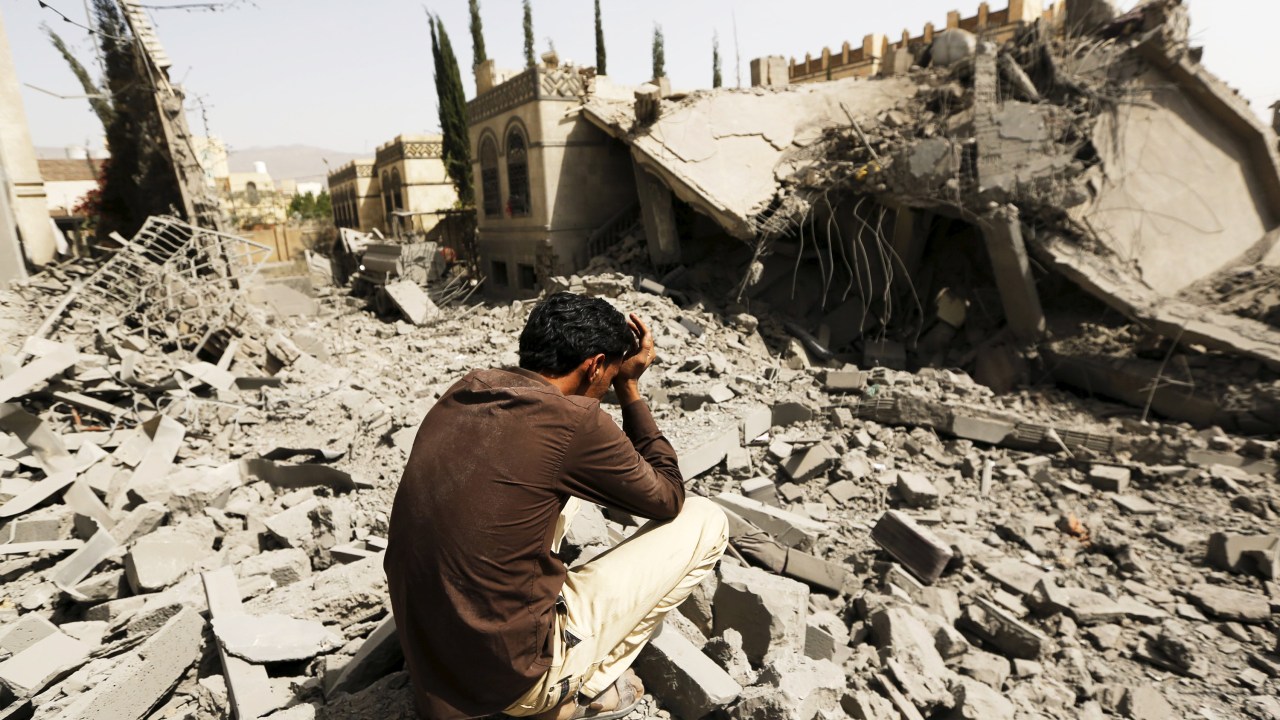 Guarda senta sobre escombros de casas destruídas após ataques aéreos em Sanaa, no Iêmen - 15/06/2015