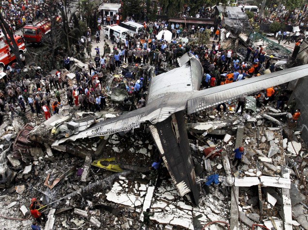 Equipe de resgate examina os destroços do avião militar, o C-130 Hercules, após queda em uma área residencial na cidade de Medan, na Indonésia