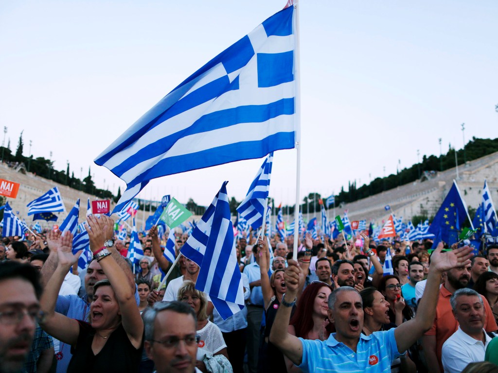 Manifestantes agitam bandeiras gregas durante um comício a favor da manutenção do país na União Europeia no estádio Panathenean em Atenas - 03/07/2015