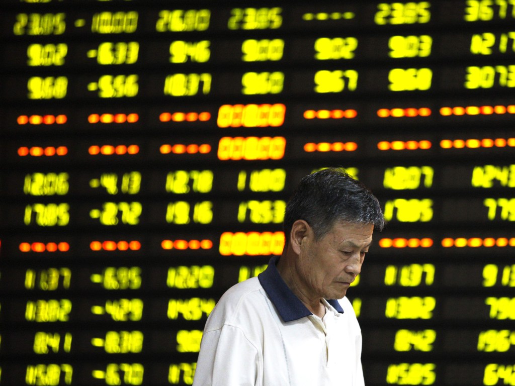 Investidor é visto em frente ao painel eletrônico com informações da bolsa, em uma corretora de Huaibei, na China. As ações no país caíram mais de 8%, sua maior queda em um dia em mais de oito anos - 27/07/2015