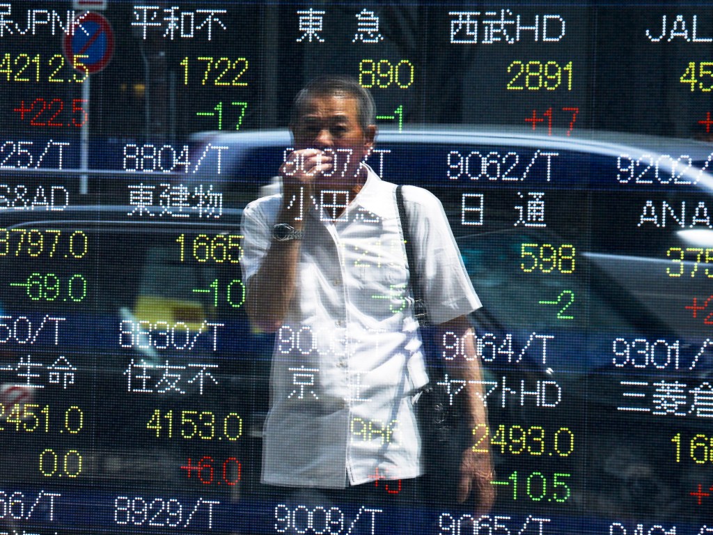 Homem acompanha painel com a cotação de ações da bolsa de valores de Tóquio, no Japão - 28/07/2015