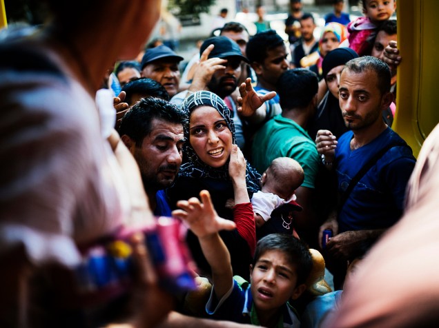 Imigrantes esperam para receber alimentos distribuídos por voluntários na estação de trem em Gevgelija, na fronteira da Macedônia com a Grécia. Muitos imigrantes tentam cruzar a Macedônia e a Sérvia para entrar na União Europeia pela Hungria - 04/08/2015