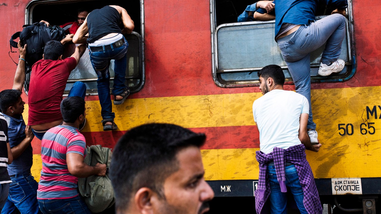 Na fronteira da Macedônia com a Grécia, imigrantes tentam embarcar em um trem a caminho da Sérvia - 07/08/2015