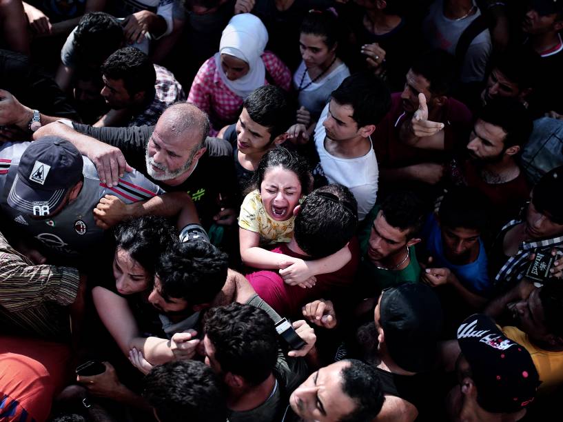 Criança chora em meio a uma multidão de imigrantes, durante um procedimento de registro em um estádio, na ilha grega de Kos - 11/08/2015
