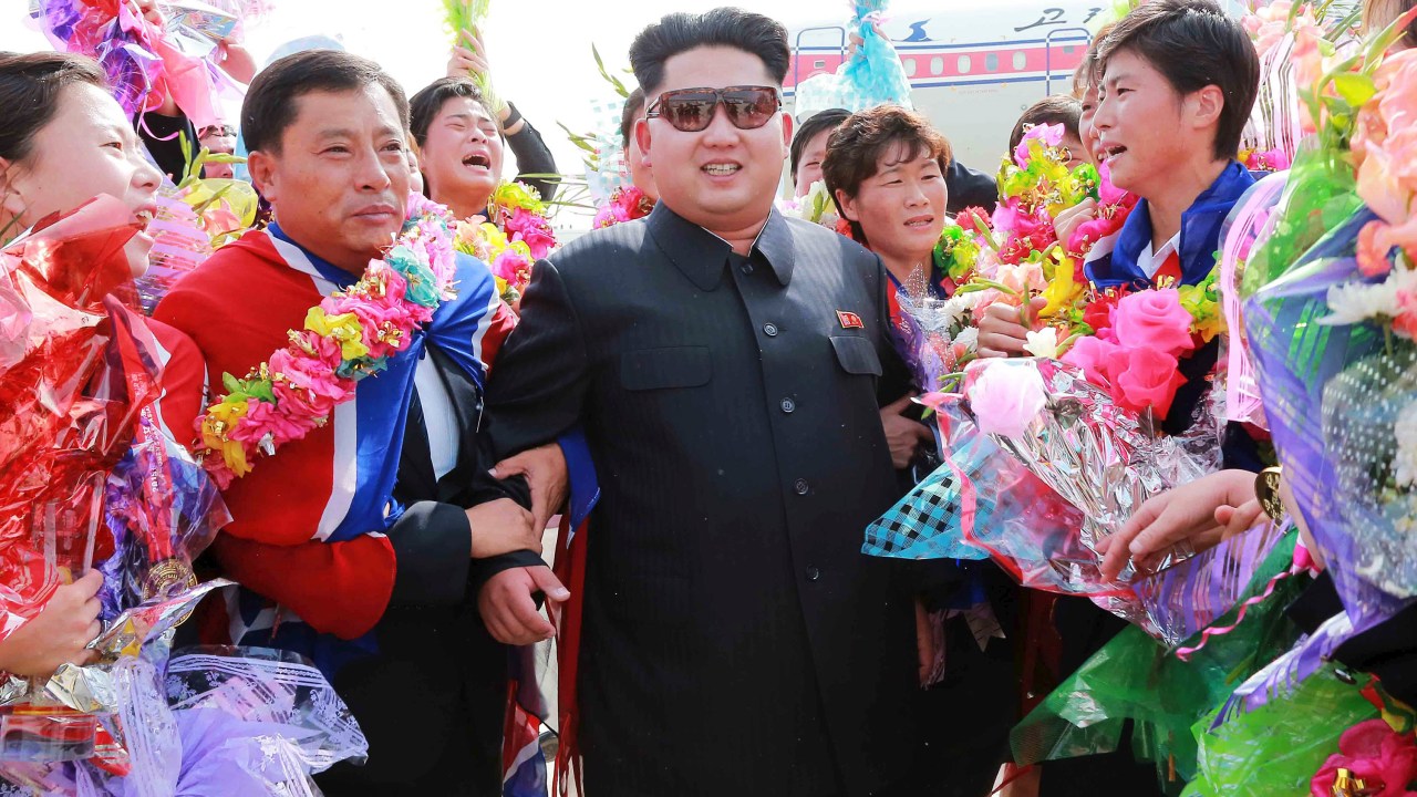 O ditador norte-coreano Kim Jong Un, cumprimenta a equipe de futebol feminino do país na chegada das atletas ao Aeroporto Internacional de Pyongyang, após conquista da Copa do Leste Asiático