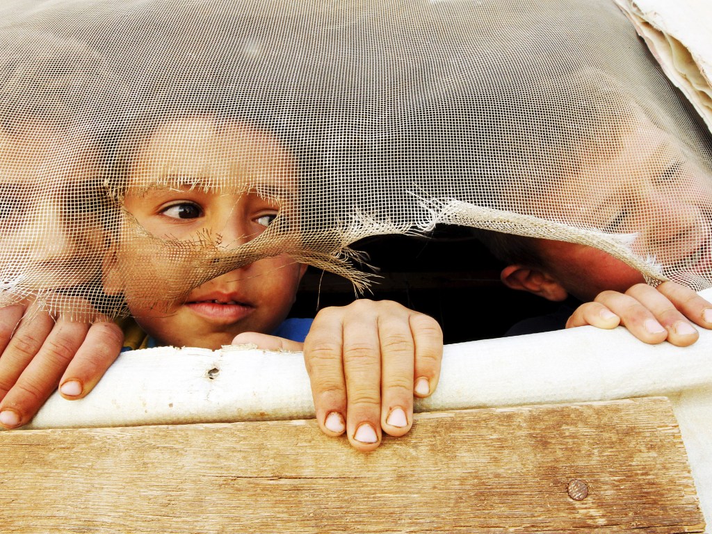Crianças refugiadas sírias olham para fora de sua tenda durante visita de Stephen O'Brien, diretor de assuntos humanitários da ONU, em Saadnayel no Vale de Bekaa no Líbano